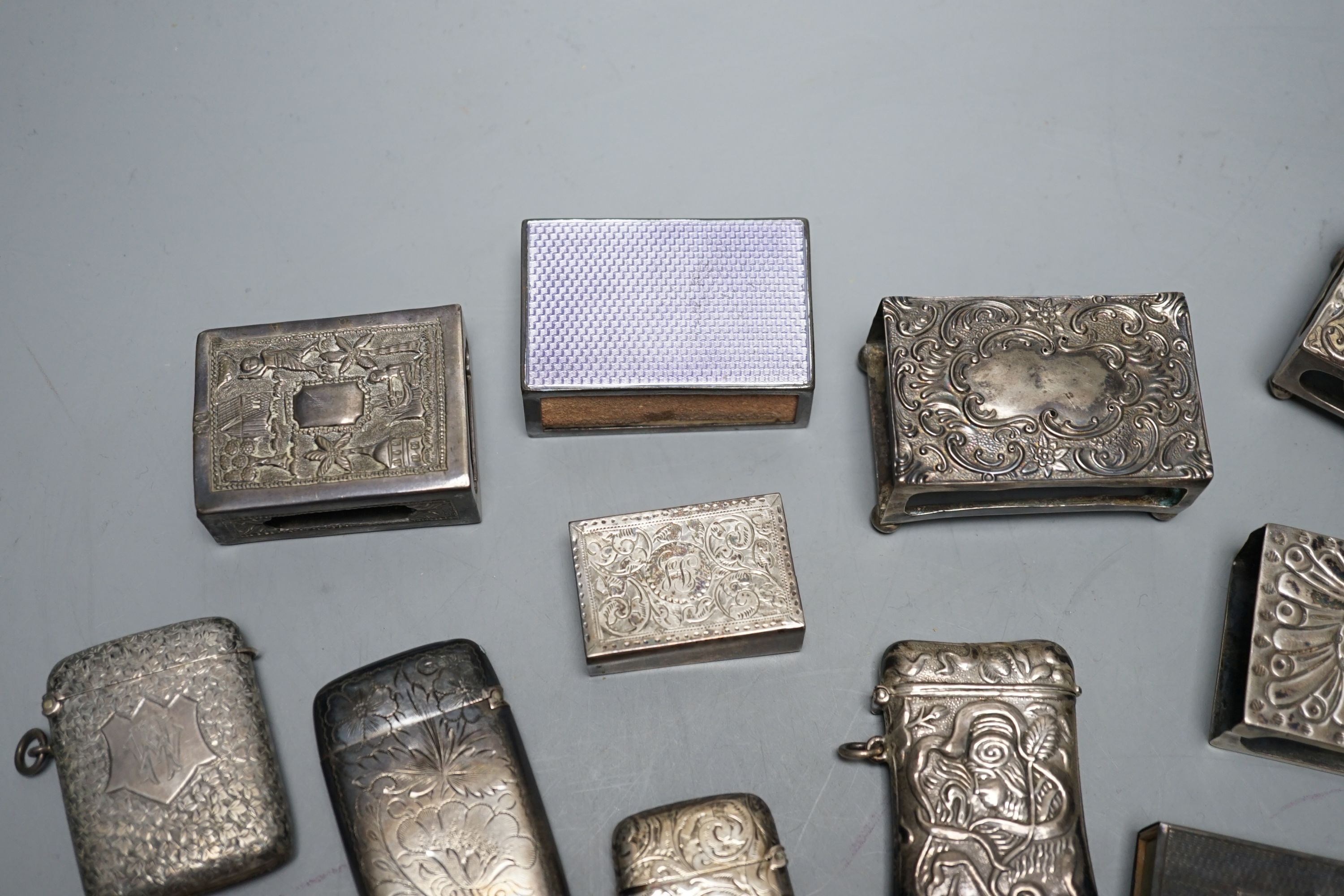 A small collection of nine mainly early 20th century silver or sterling vesta cases, largest 60mm and fourteen assorted similar silver or white metal match sleeves